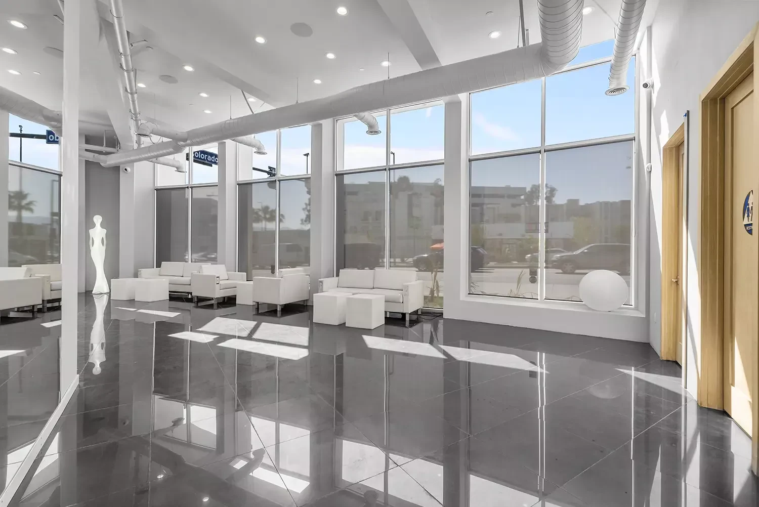 Main hall interior — polished floors, floor-to-ceiling windows, and white lounge seating