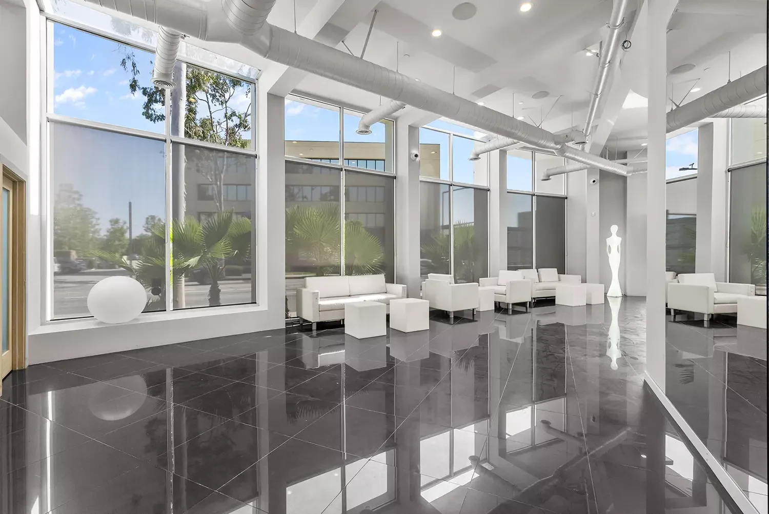 Private meeting room with white seating and floor-to-ceiling windows